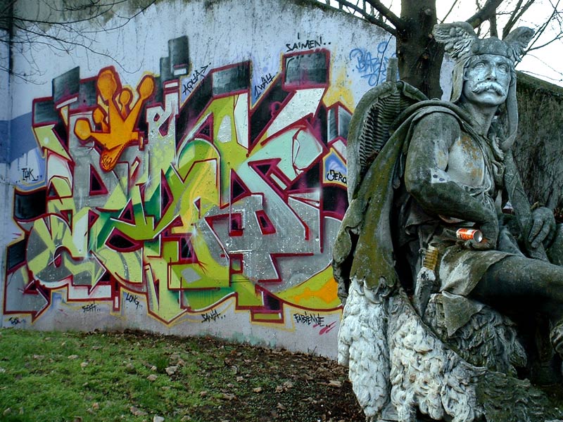 Denkmal eines Schwertkämpfers vor Betonwand mit Graffity
